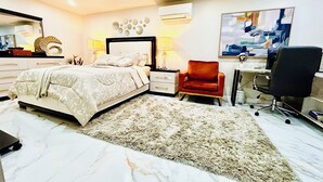 Ein Schlafzimmer mit Bett, Schreibtisch, Stuhl und Teppich.
