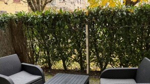 Eine Terrasse im Freien mit Korbmöbeln, darunter zwei Sofas und ein Tisch.