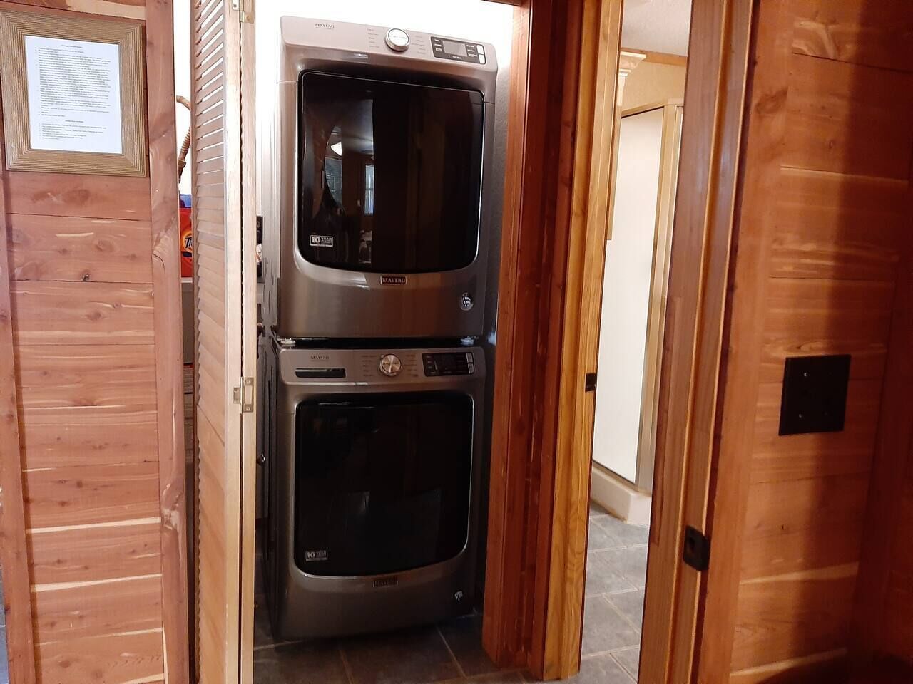 A compact kitchen with two stainless steel ovens and a wooden door.