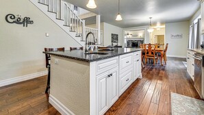 A spacious kitchen with a large island, wooden flooring, and pendant lighting. - Limpy Creek Access! Family Retreat in Grants Pass (Grants Pass)
