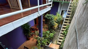 Un espace extérieur à plusieurs niveaux, agrémenté d’escaliers, de rampes et de plantes en pot.