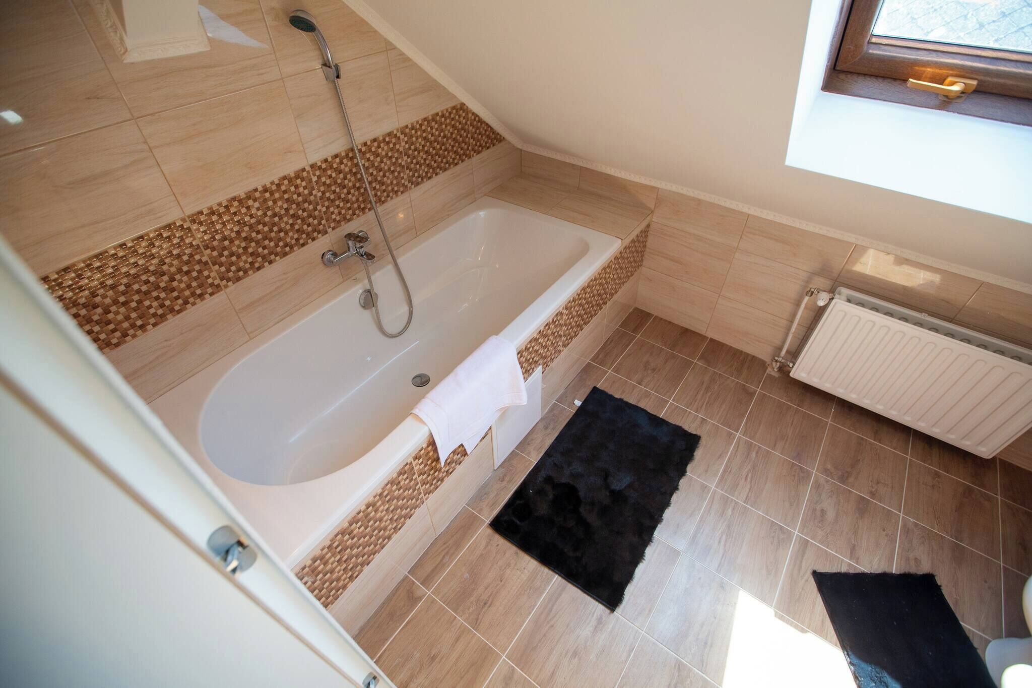 Ein Badezimmer mit einer Badewanne, einer Dusche und einem Fenster.