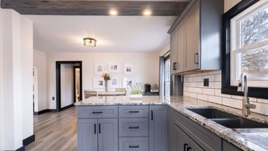 Una cocina moderna con armarios grises, encimeras de granito y una isla central.