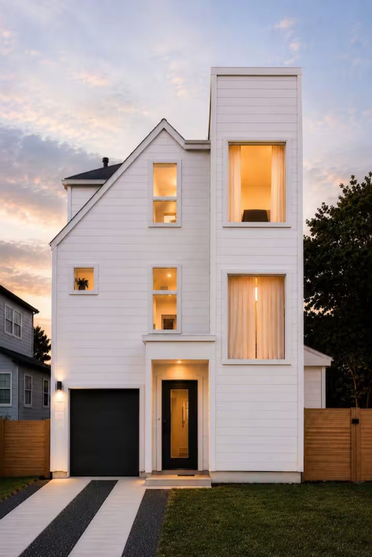 A modern two-story house with a garage, a front door, and multiple windows.