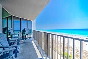 Ein Balkon mit Stühlen und Blick auf einen Strand.
