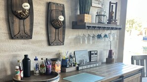 Un rincón de bar rústico con estantes de madera que exhiben copas de vino, un cartel de vino y un letrero que dice 'Mis regiones de vino favoritas'.