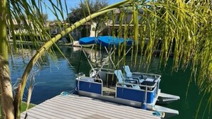 Un muelle con un bote, una zona techada y una plataforma de madera.