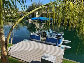 Un quai avec un bateau, un espace abrité et une plateforme en bois.