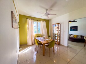A dining area with a table, chairs, a ceiling fan, and a view of the outdoors. - Spacious Family Home Near Beaches, Surf, Restaurants & Nature (rincón)