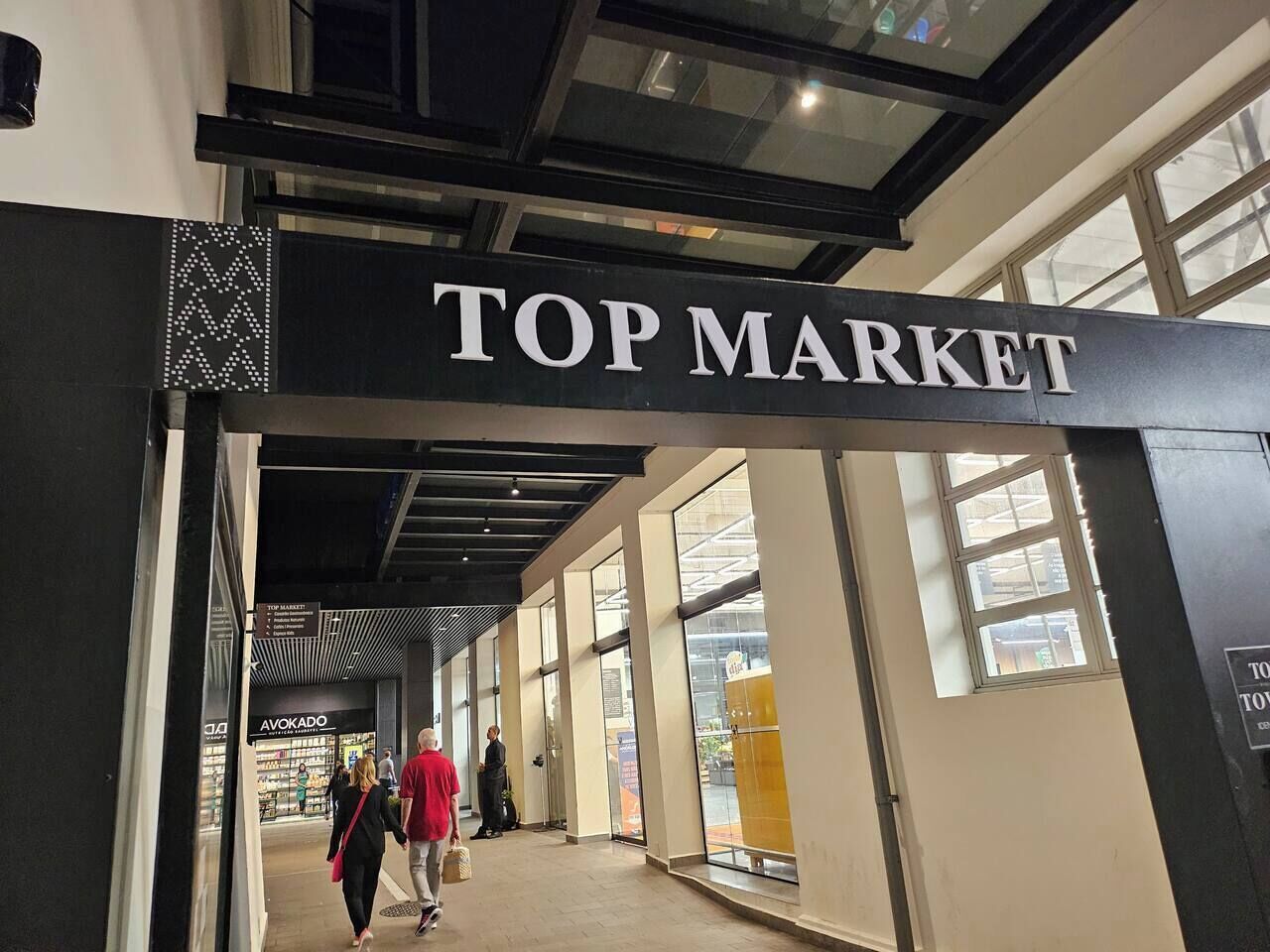 Un espace commercial intérieur avec une enseigne indiquant « TOP MARKET ».