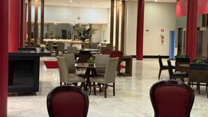 A spacious lobby with a central seating area, red pillars, and a modern design. - HOTEL DUNAMYS (Londrina)