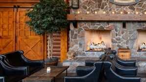 A cozy outdoor seating area with stone fireplaces, leather chairs, and a wooden door. - Relax in Gatlinburg w/cool mountain views, FUN activities for all in the family! (Gatlinburg)