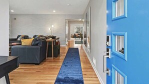 Een moderne woonkamer met een blauwe accentmuur, houten vloer en een blauw vloerkleed.