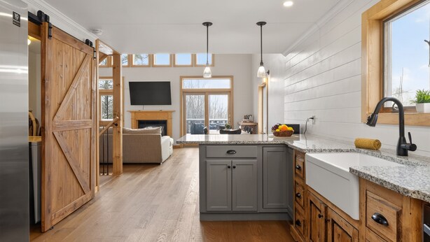 A modern kitchen with a wooden door, grey cabinets, and a large window. - Private Naples Retreat | Near Wineries | Hot Tub (Naples)
