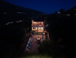 A two-story building with a balcony, a patio area, and a driveway leading to the entrance. - Effie's Escape Spacious House in Zola (Argostoli)
