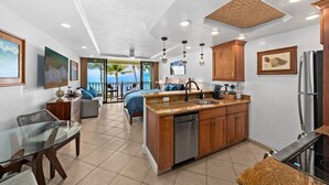 Una cocina moderna con una isla central, armarios de madera y un refrigerador de acero inoxidable.
