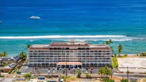 Hotel de varios pisos con estacionamiento, cerca de una playa y vistas al océano.
