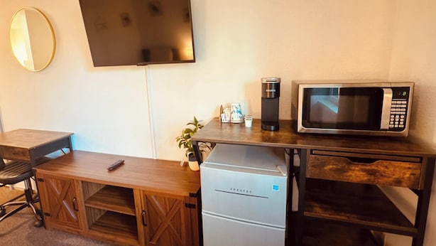 Une petite cuisine équipée d’un four à micro-ondes, d’une machine à café et d’un réfrigérateur.