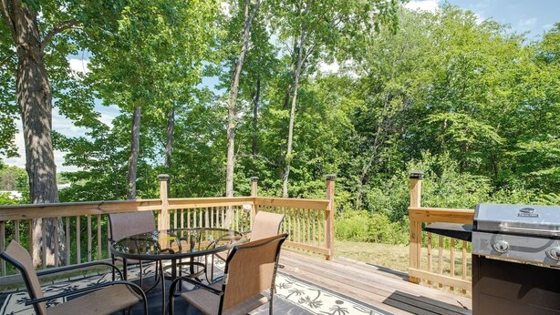 A deck with a grill, chairs, and a table. - •	Quiet 3BR Home Close to Biddeford Beaches (Biddeford)