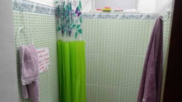 Chuveiro, toalhas de banho, sabonete, papel higiênico