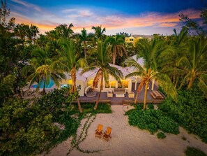A resort with a pool, outdoor seating, and palm trees. - Limefish Luxury - Gulf Front Pool -Sunset Views -Beach Access (Holmes Beach)