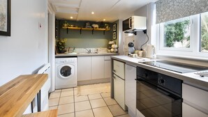 A compact kitchen with a washing machine, a built-in oven, and a microwave. - Hillside - Two bedroom Terrace, 1-mile from Silecroft Beach - Dog-friendly (Silecroft)