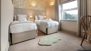 A hotel room with two beds, a large window, and a view of greenery outside. - Hillside - Two bedroom Terrace, 1-mile from Silecroft Beach - Dog-friendly (Silecroft)