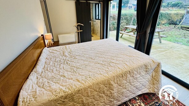 Un dormitorio con una cama grande, una ventana y vistas al exterior.