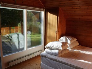 A room with a bed, a window, and wooden walls. - Nature oasis with private lake near beach (Fårevejle)