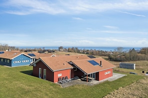 A residential area with multiple houses, including a red house with a patio and solar panels. - Sea view, spa and space for the whole family (Augustenborg)
