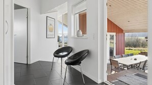 Een modern interieur met een eethoek, twee zwarte stoelen, een witte tafel en uitzicht op de omgeving.