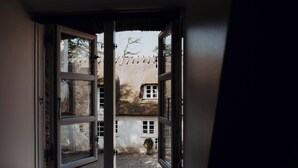 An open doorway leading to a courtyard with a building in the background.