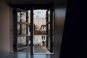 Un umbral abierto que da a un patio con un edificio al fondo.