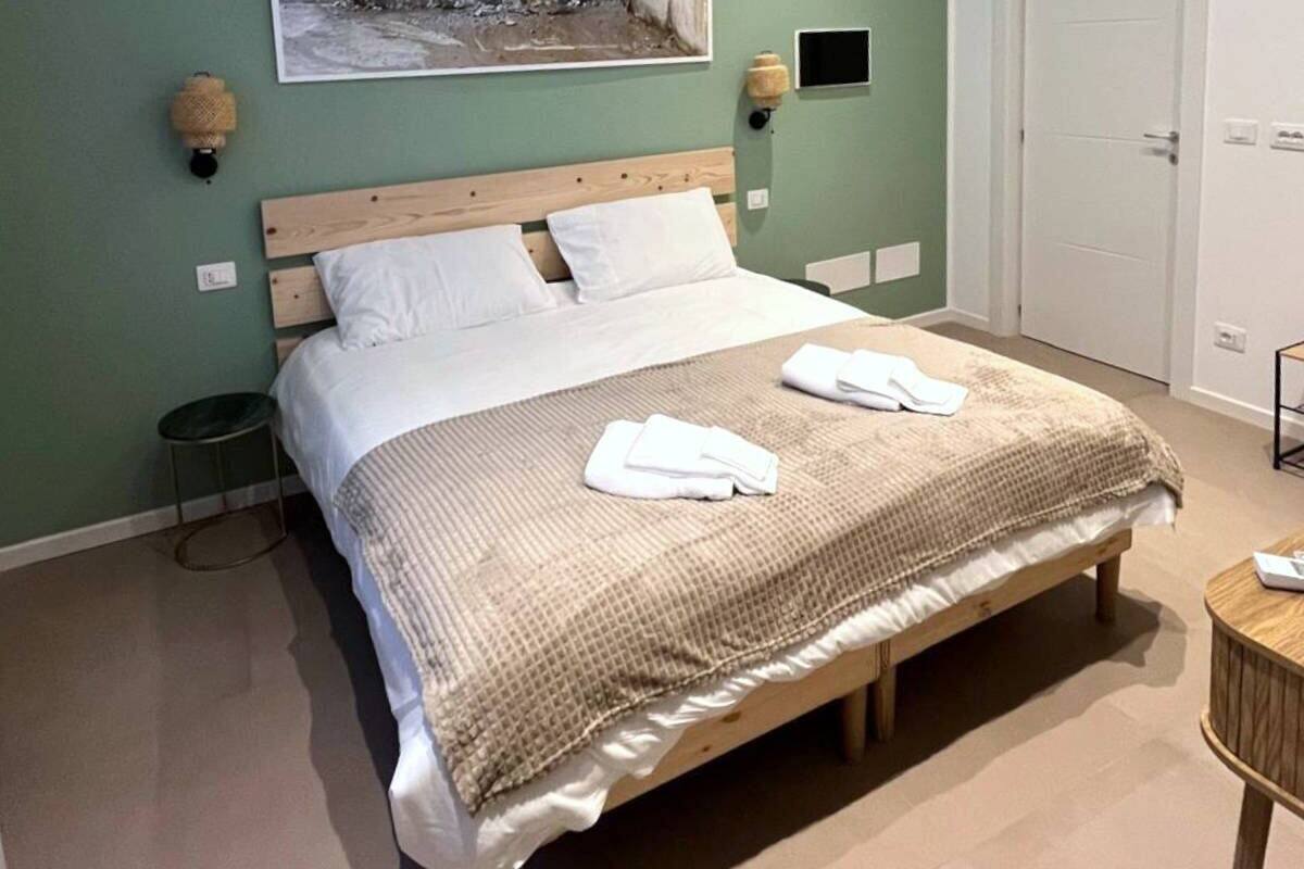 Ein Schlafzimmer mit einem Bett, einem Wandbild, einer Tür und einem kleinen Tisch.