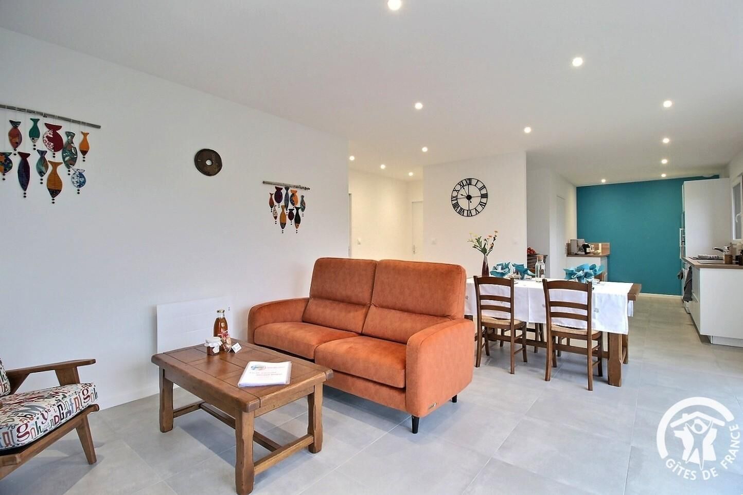 Een woonkamer met een bank, salontafel en een eethoek met stoelen en een tafel.