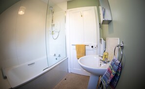 A bathroom with a bathtub, a sink, and a mirror. - Mill Cottage - a tranquil cottage location for 4 guests (Forres)
