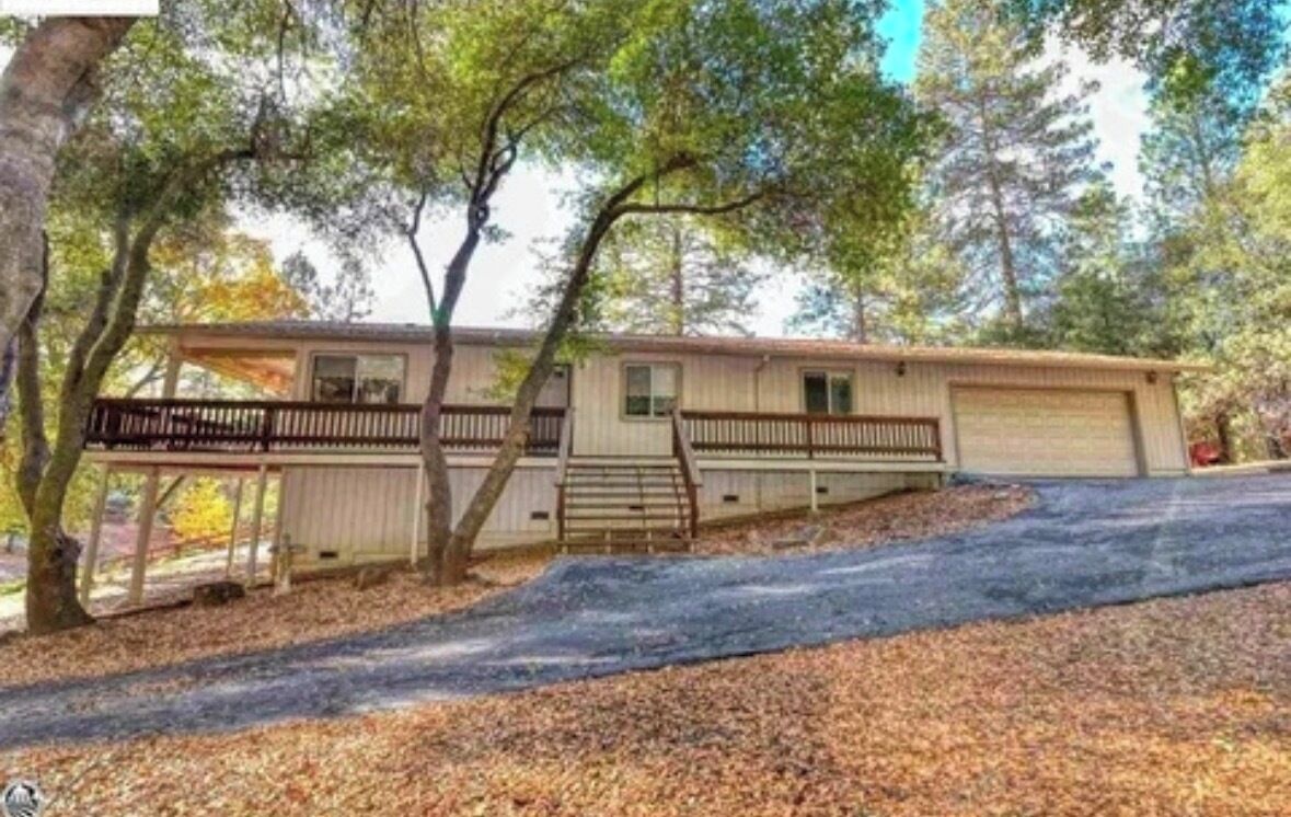 A single-story house with a front porch, a garage, and a covered driveway.
