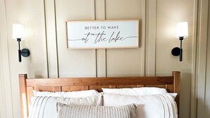 A neatly made bed with a wooden headboard, two wall-mounted lamps, and a framed motivational quote on the wall. - Recently Renovated 3 Bedroom house in Groveland with Central Heating and Air (Groveland)
