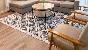 A living room with a sectional sofa, a round coffee table, and a patterned rug. - Recently Renovated 3 Bedroom house in Groveland with Central Heating and Air (Groveland)