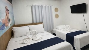 A hotel room with two beds, a painting on the wall, a flat-screen TV, and a ceiling light. - Pousada Doce Mar: Comfort and tranquility just steps from the beach. (Maragogi)