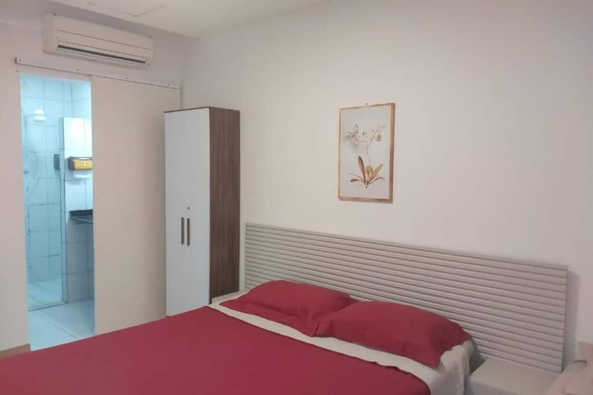 Un dormitorio con cama, armario y un cuadro colgado en la pared.