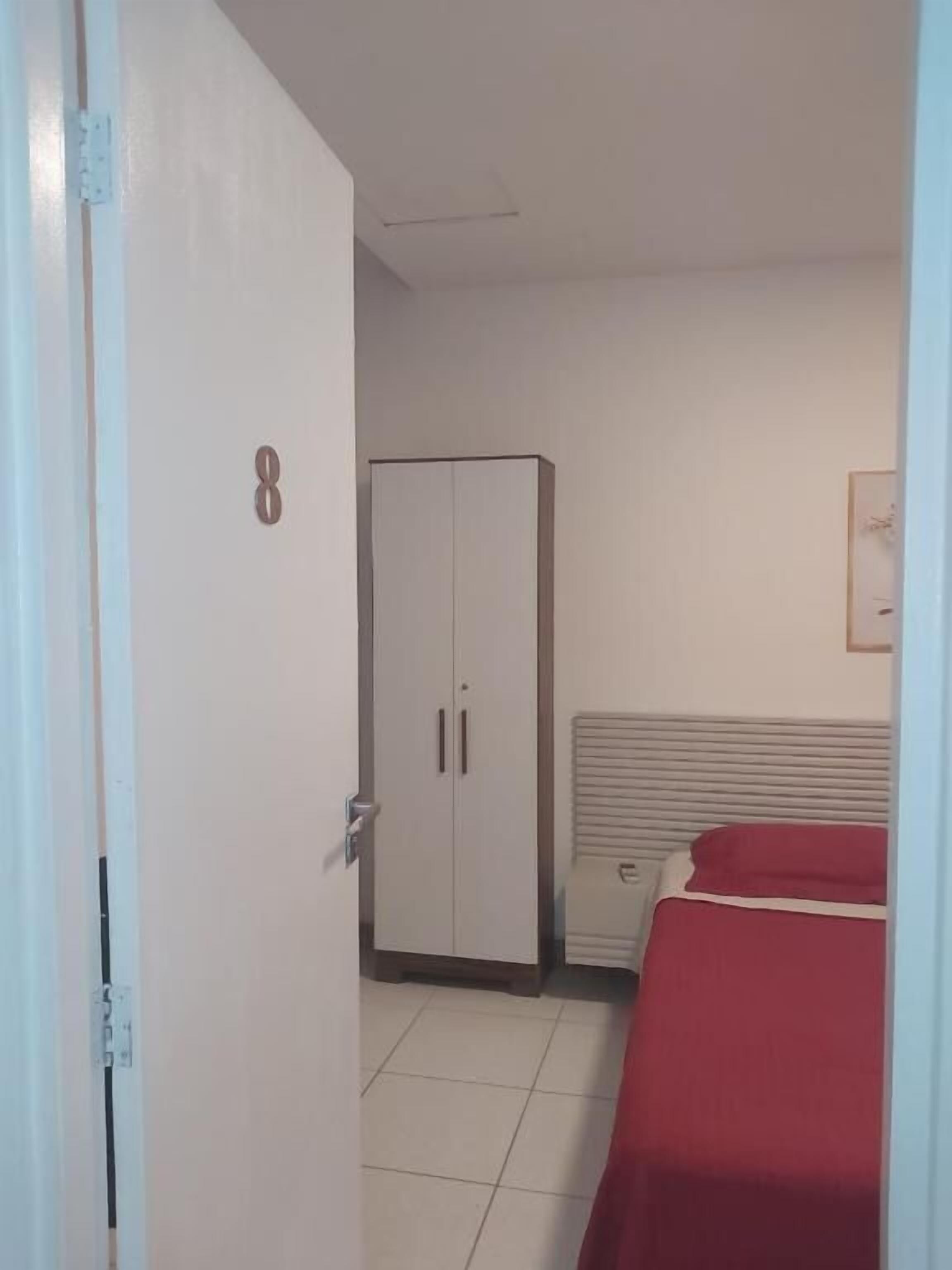 Una habitación con una cama, un armario y una puerta con el número 8.
