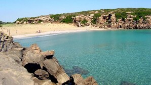 A coastal beach with clear turquoise water, rocky formations, and a sandy shore. - Casa Alba Serena by the sea (Marzamemi)