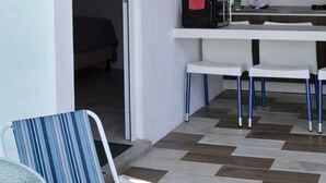 A compact kitchen with a microwave, kettle, and a small dining table with chairs. - Modern Apartment w Private Pool (Chiquimulilla)