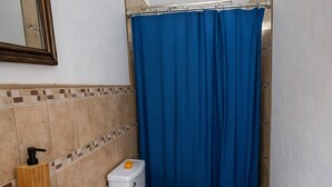 A small bathroom with a sink, toilet, and shower curtain. - Modern Apartment with Private Pool (Chiquimulilla)