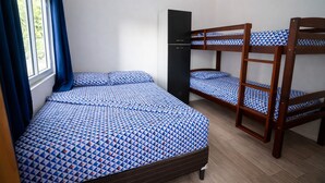 A dormitory room with bunk beds and a single bed, a wardrobe, and a window with curtains. - Modern Apartment with Private Pool (Chiquimulilla)