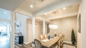 A dining area with a wooden table, chairs, and a chandelier. - Spacious, 5 Bedroom/3.5 Bath In The Hear of Ocean City (Ocean City)