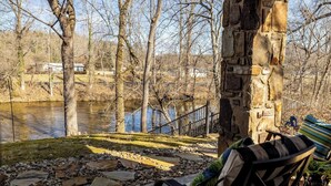 Un pilier de pierre, une chaise, un banc, un sentier de pierre et une rivière.