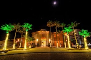 A hotel with a prominent entrance, palm trees, and a well-lit facade. - Grande 502, Las Palmas Resort (Puerto Peñasco)
