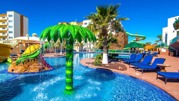 A swimming pool with a water slide, palm trees, and lounge chairs. - Delphin 504 Las Palmas Resort (Puerto Peñasco)